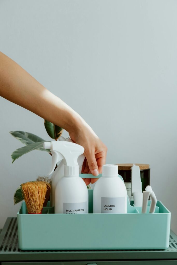 pexels-photo-10557498-10557498 Hand arranging cleaning products in a tidy organizer, promoting cleanliness and order.